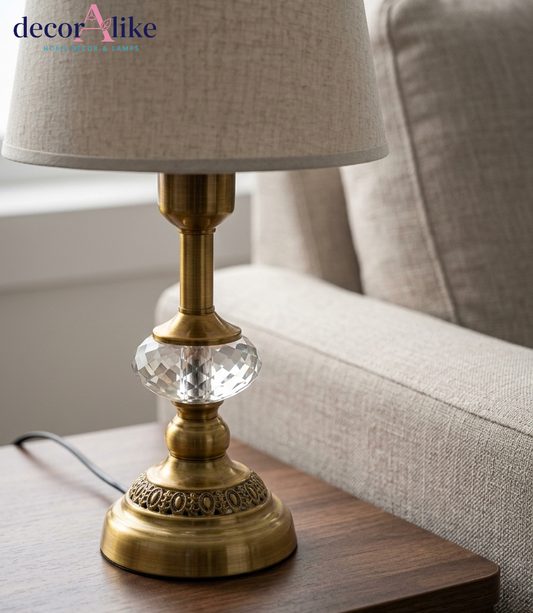 Antique brass table lamp with faceted crystal detail, embossed filigree base and beige linen drum shade