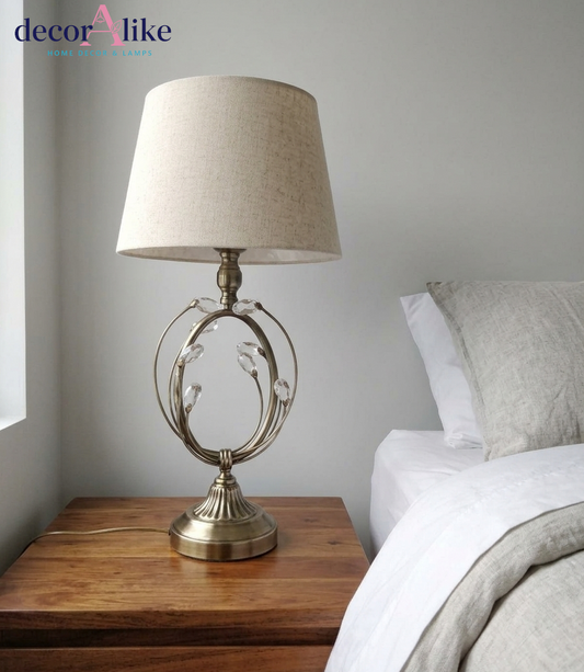 Antique brass table lamp with open loop cage, crystal petal detailing and beige linen drum shade