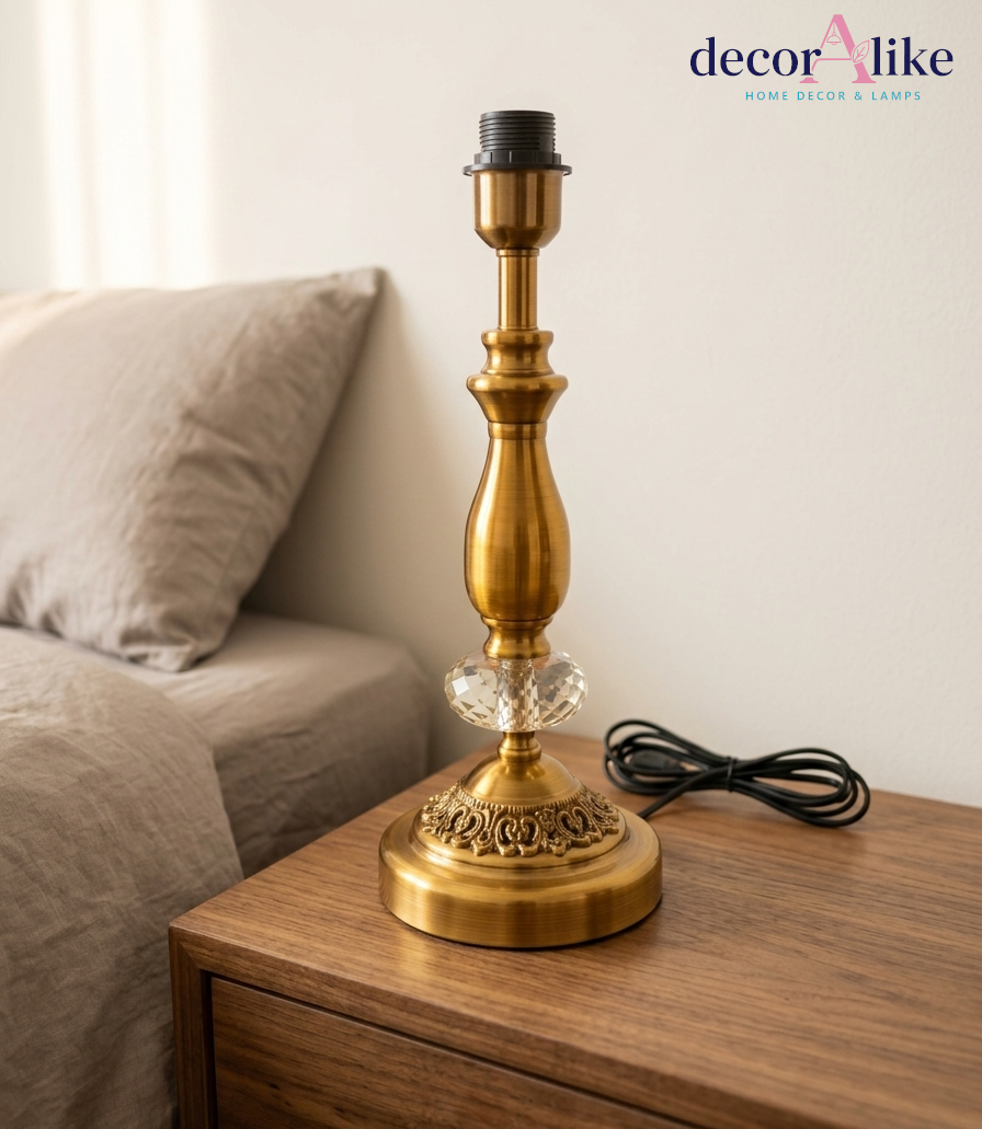 Antique brass table lamp with crystal accent and beige linen shade on wooden nightstand — Decoralike Pakistan