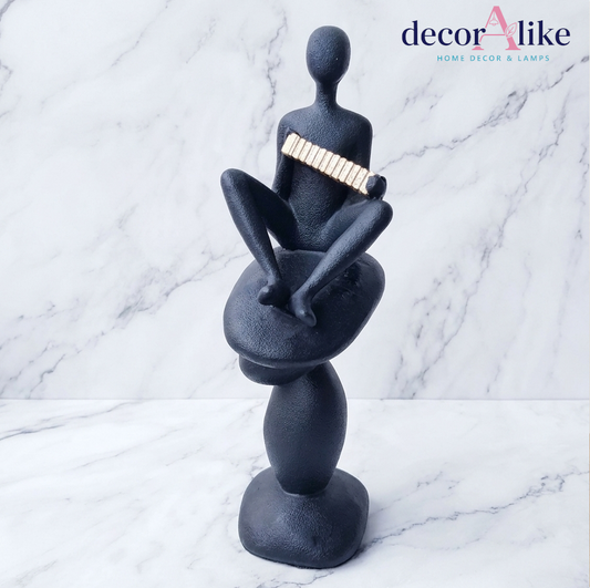 Meditative figure sculpture with gold accent on textured black base – Decoralike Lahore