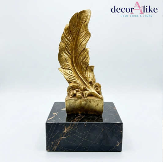 Gold quill feather sculpture on black marble base – Decoralike Lahore