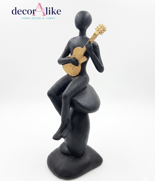Faceless figure playing guitar sculpture in matte black and gold – Decoralike Lahore