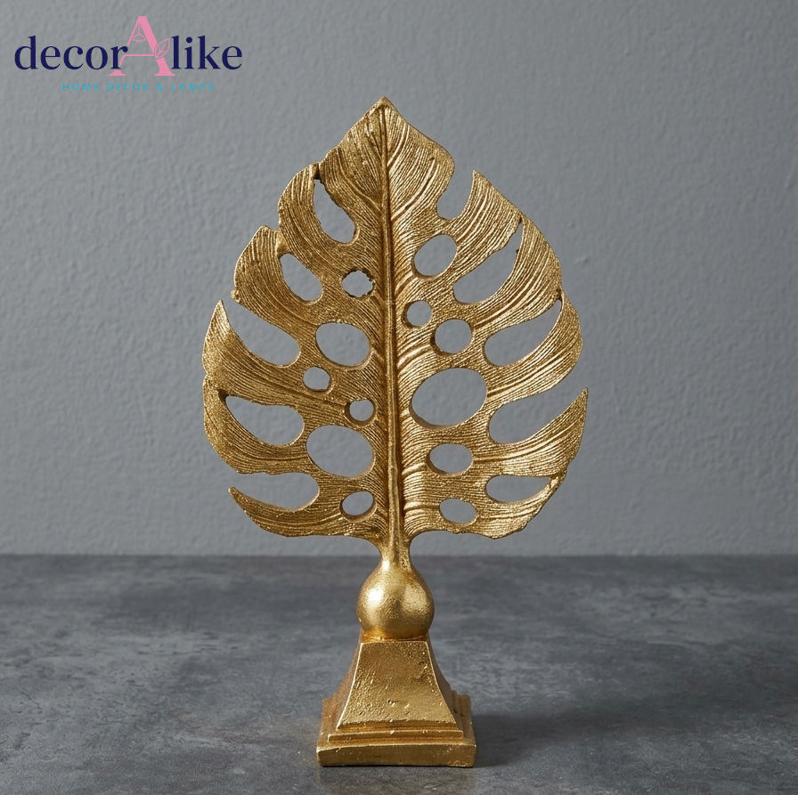 Gold monstera leaf sculpture on pedestal base – Decoralike Lahore