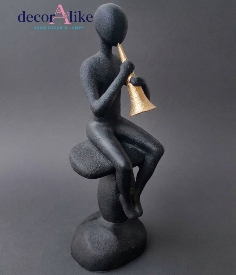 Faceless figure playing trumpet sculpture in matte black and gold – Decoralike Lahore
