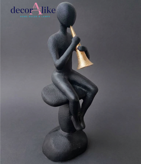 Faceless figure playing trumpet sculpture in matte black and gold – Decoralike Lahore