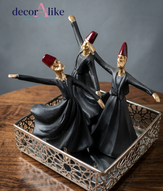 Set of three whirling Sufi statues in black and gold on decorative silver tray