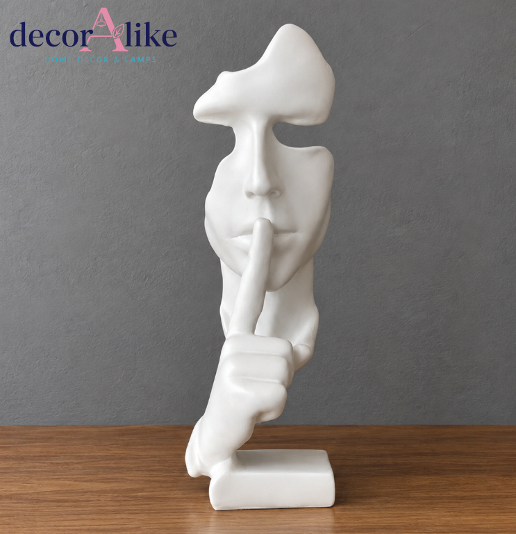 Modern white abstract face sculpture with shh finger gesture