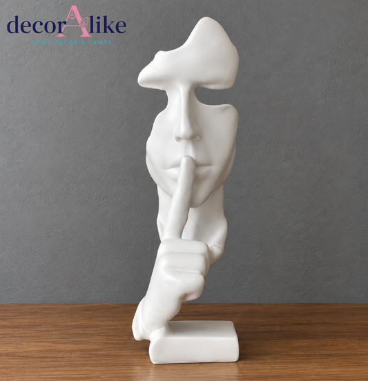 Modern white abstract face sculpture with shh finger gesture
