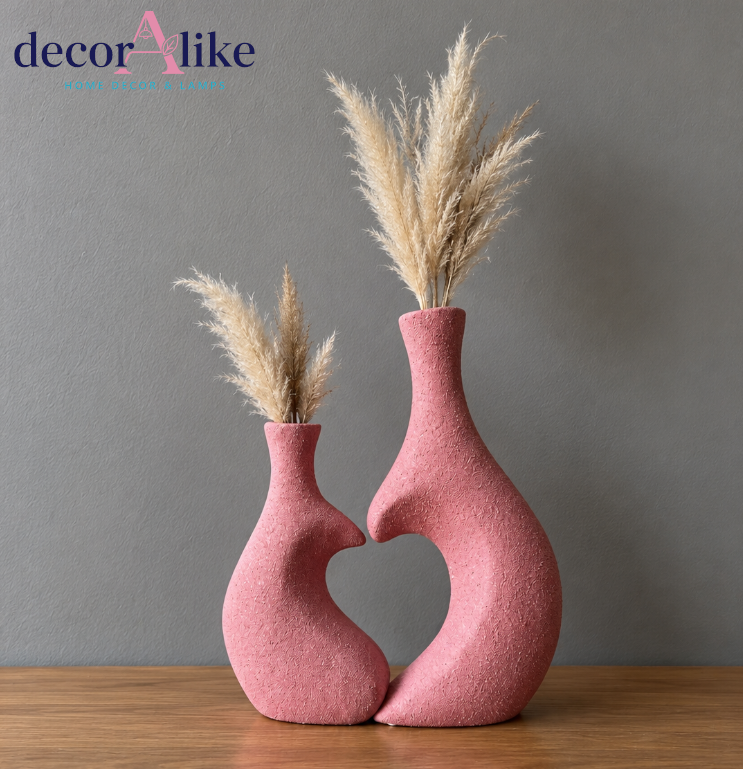 Set of two pink heart-shaped decorative vases with dried pampas grass