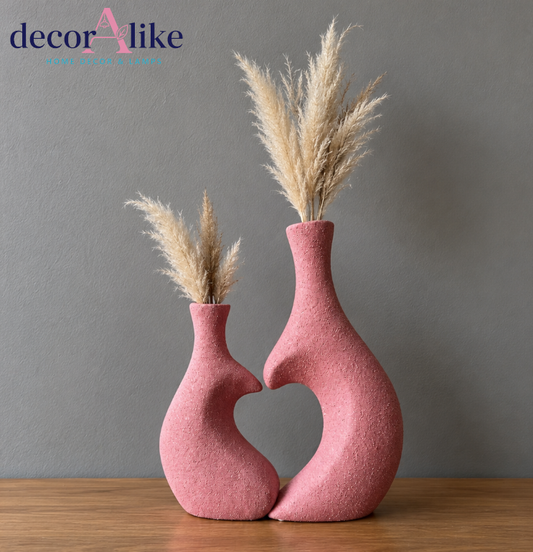Set of two pink heart-shaped decorative vases with dried pampas grass