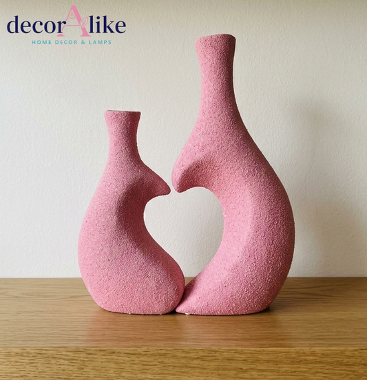 Set of two pink heart-shaped decorative vases with dried pampas grass