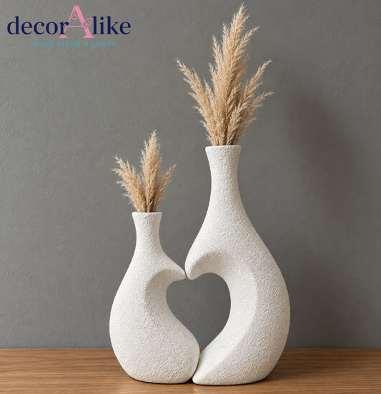 Set of two white heart-shaped decorative vases with dried pampas grass