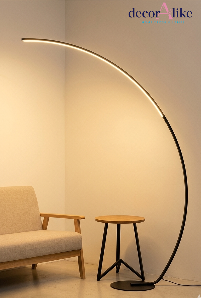 Matte black arc LED floor lamp curving over a beige sofa in a modern living room