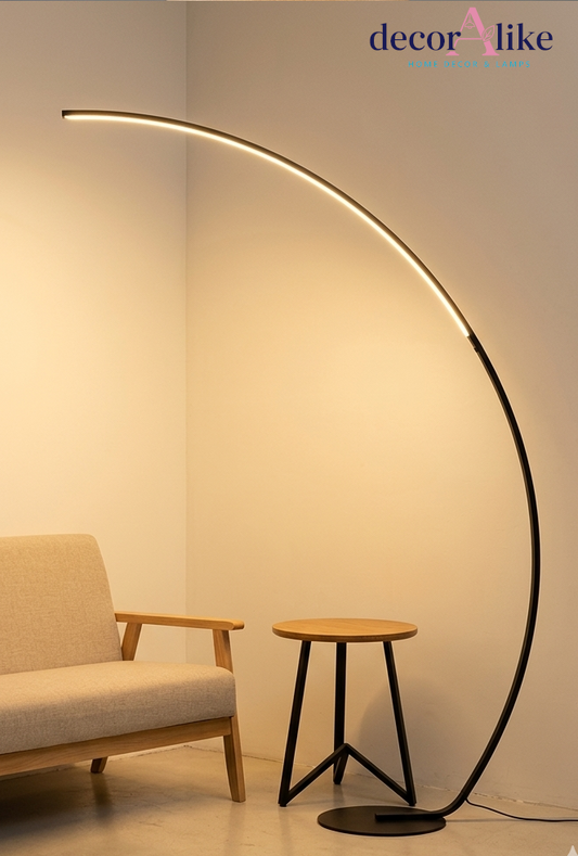 Matte black arc LED floor lamp curving over a beige sofa in a modern living room