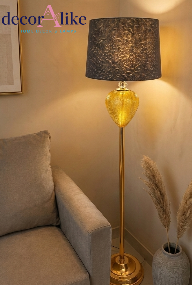 Gold crystal floor lamp with amber glass teardrop base 
and textured charcoal shade glowing in living room corner