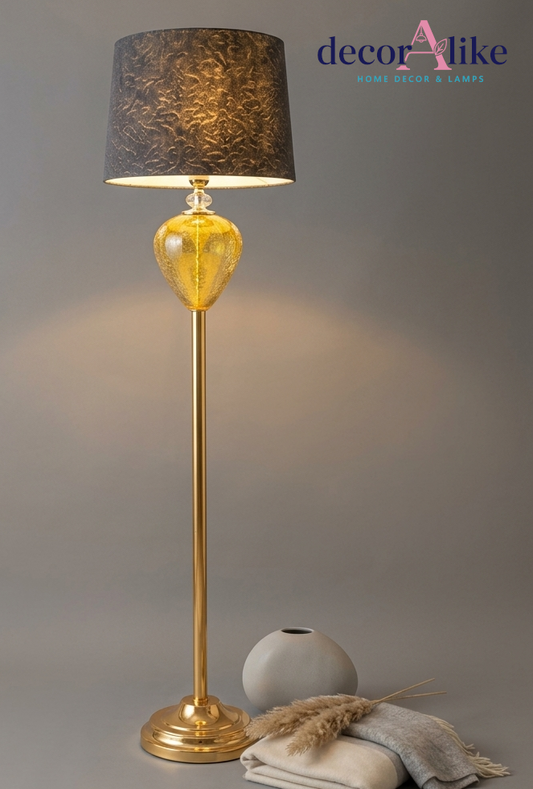Gold crystal floor lamp with amber glass teardrop base 
and textured charcoal shade glowing in living room corner