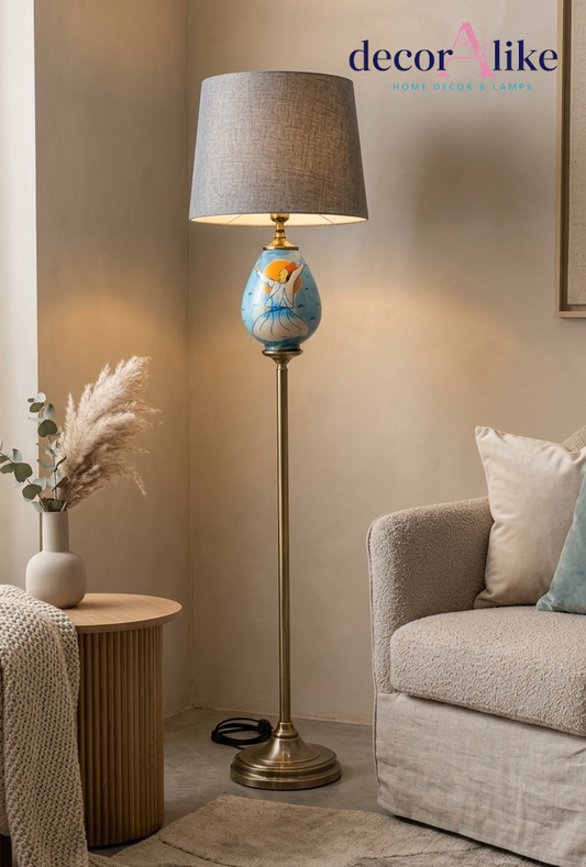 Hand-painted whirling dervish floor lamp with brass pole and pleated grey shade in a living room corner