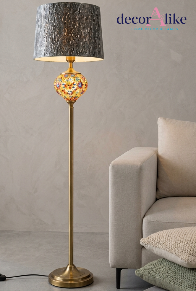 Multicolour mosaic glass floor lamp with brass pole and textured grey shade in a modern lounge