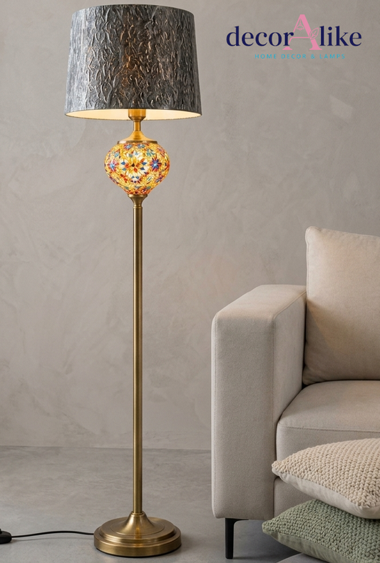 Multicolour mosaic glass floor lamp with brass pole and textured grey shade in a modern lounge