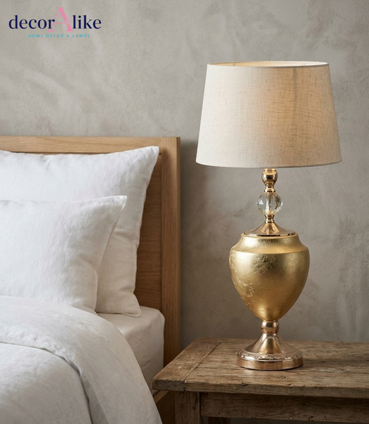 Luxury gold urn table lamp with crystal accent and beige linen shade on rustic wooden table - DecorAlike Pakistan