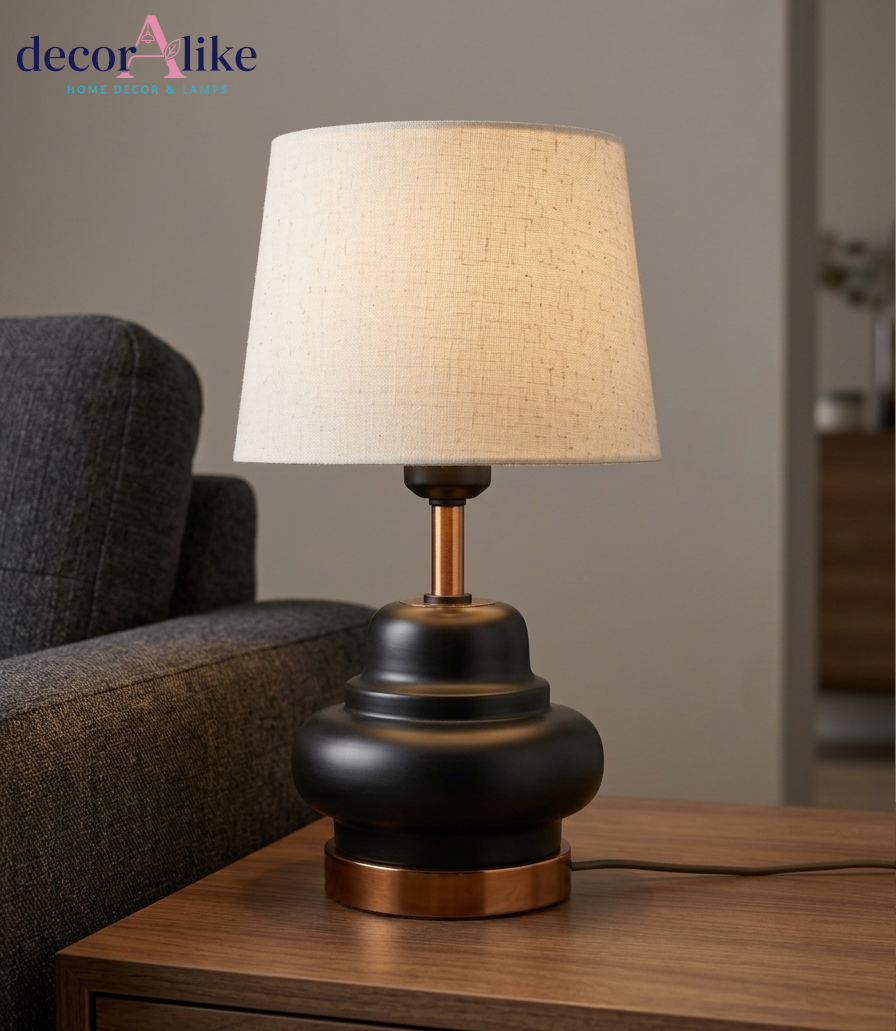 Black table lamp with copper accents and cream linen shade on wooden side table — small bedside lamp Pakistan