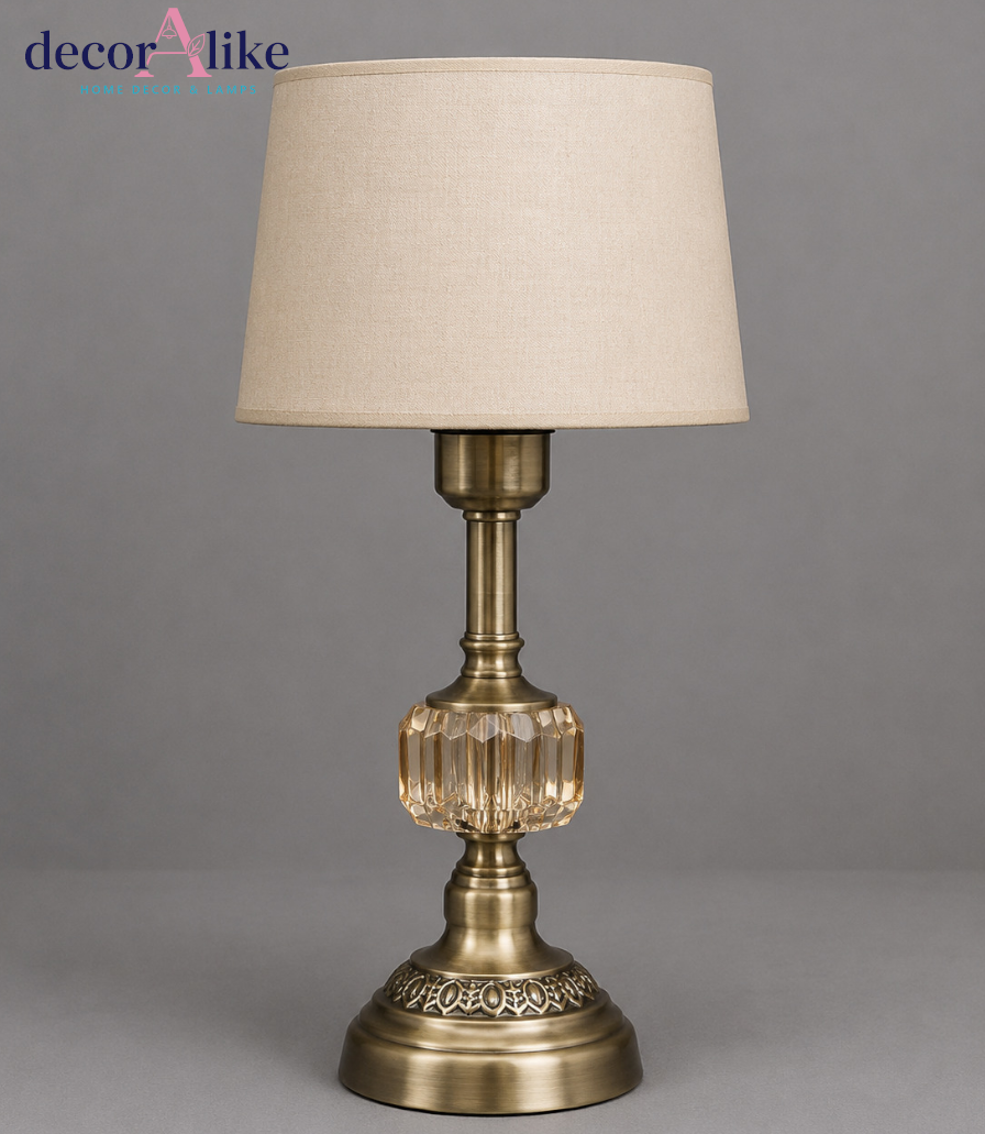Antique brass table lamp with amber faceted crystal centrepiece, filigree base and beige linen drum shade
