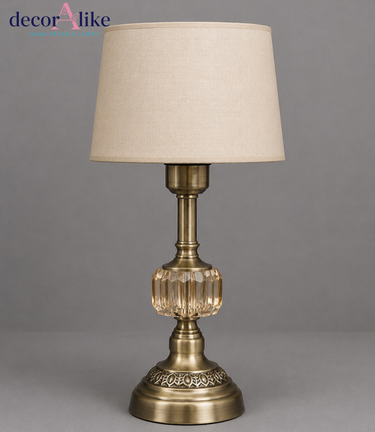 Antique brass table lamp with amber faceted crystal centrepiece, filigree base and beige linen drum shade