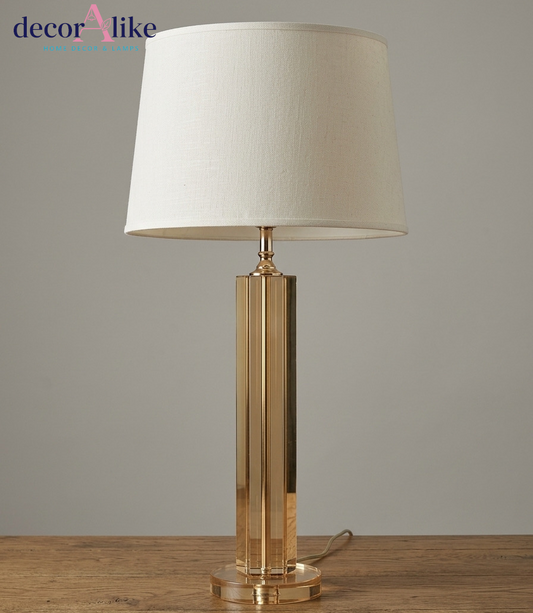 Amber crystal column table lamp with faceted panels, crystal base and ivory linen drum shade