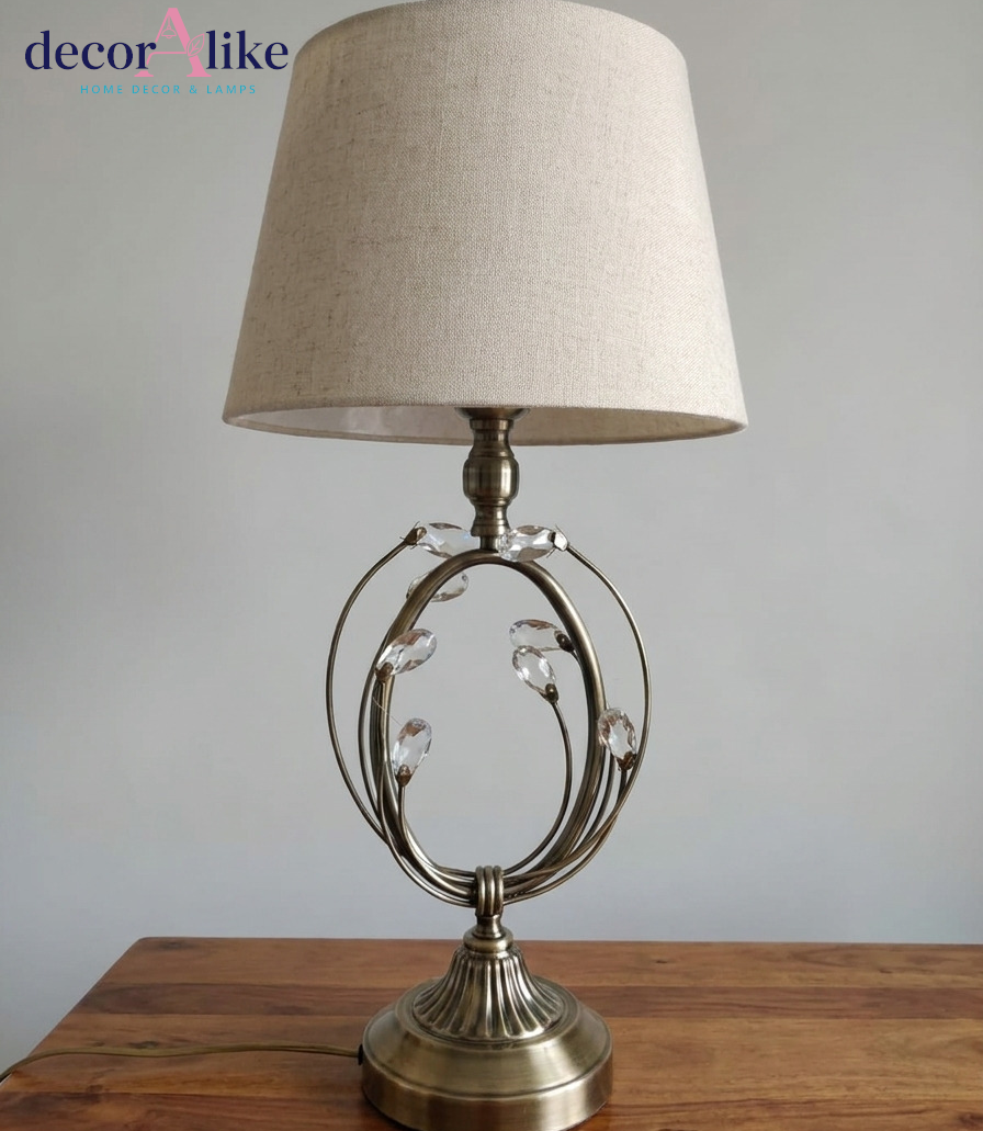 Antique brass table lamp with open loop cage, crystal petal detailing and beige linen drum shade