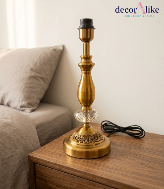Antique brass table lamp with crystal accent and beige linen shade on wooden nightstand — Decoralike Pakistan