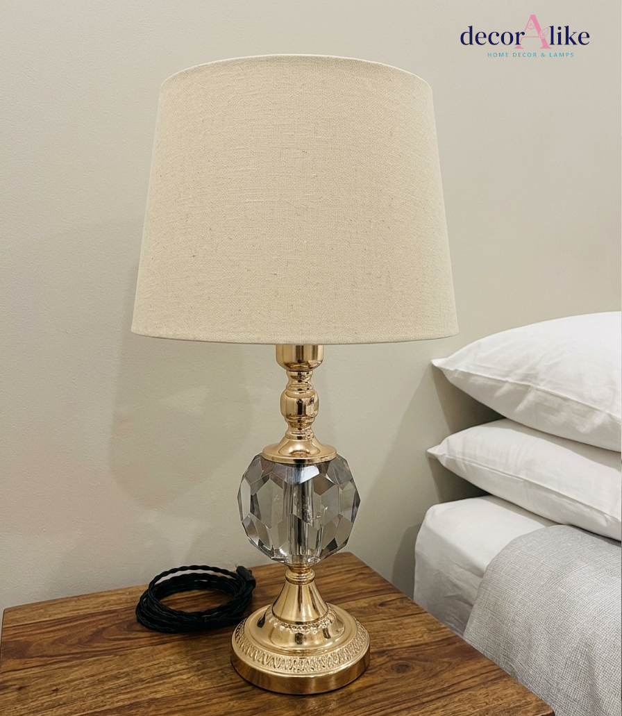 Crystal ball table lamp with antique brass base and beige linen shade on wooden nightstand — small bedside lamp Pakistan